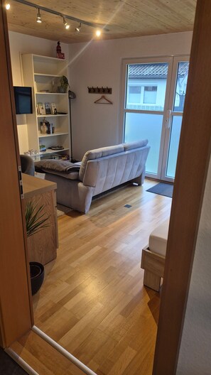 A modern living room with a sofa, a bookshelf, and a dining area. - Guest House 'Monday's Ferienwohnung' with Wi-Fi (Wehr)