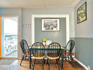 A dining area with a table and four chairs, a framed picture on the wall, and a view through an open door. - Dream Suite near LaHave River in DT Bridgewater (Bridgewater)