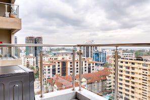 Um edifício alto com vista panorâmica da cidade através de uma varanda de vidro.