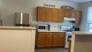 A kitchen with wooden cabinets, a microwave, and a stove.