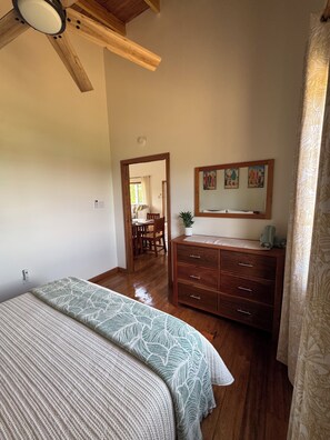 A bedroom with a bed, wooden dresser, and a ceiling fan. - Private Home + FREE Jaguar Reef Resort Access (Hopkins)