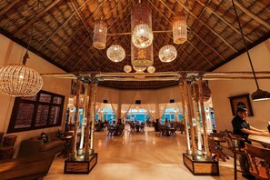A spacious indoor area with a high ceiling, multiple hanging light fixtures, and a view through large windows. - Private Home + FREE Jaguar Reef Resort Access (Hopkins)