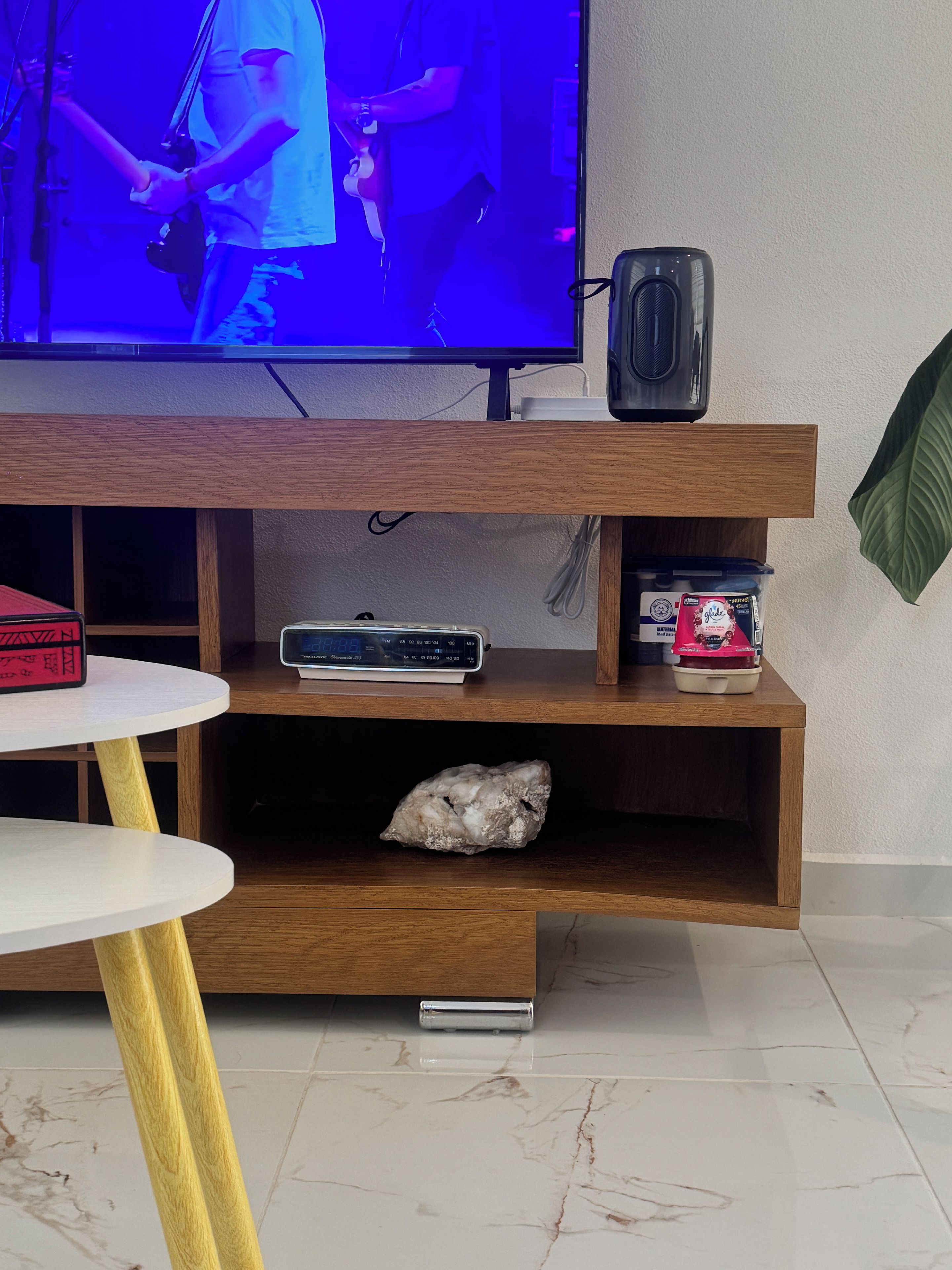 Ein Unterhaltungsschrank aus Holz mit einem Fernseher, einem Lautsprecher und einer Uhr.