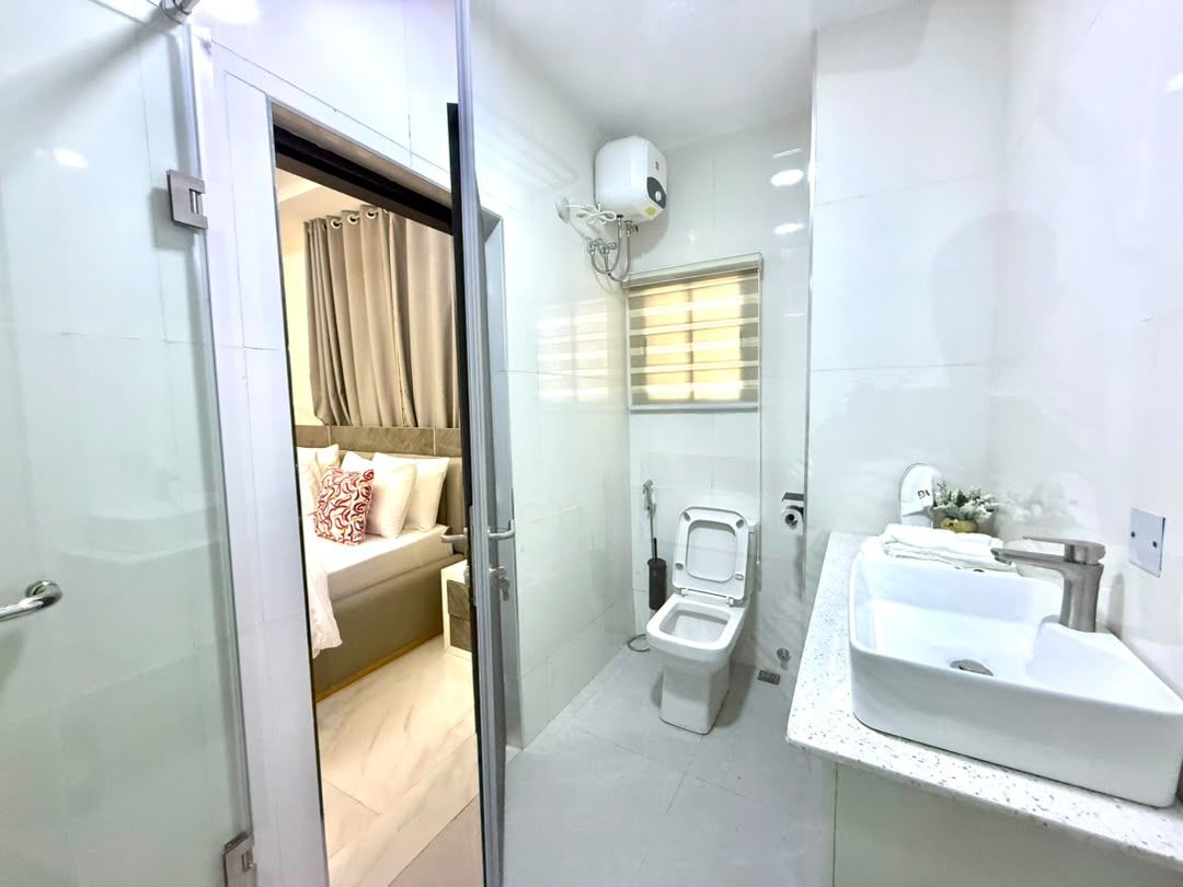 Un baño con inodoro, lavabo y zona de ducha.