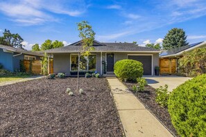 A residential house with a front yard, driveway, and garage. - Spacious Furnished 5BR Denver Home, Pet-Friendly, Fenced Yard & Garage (Denver)