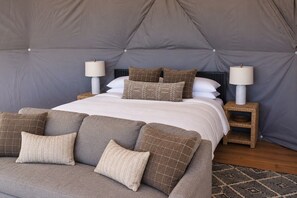 A tented accommodation room with a bed, two bedside tables, and a sofa. - Sunset Ridge - Kelly Canyon Dome (Ririe)
