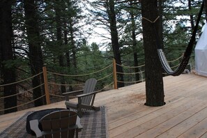 A wooden deck with Adirondack chairs, surrounded by trees and ropes. - Pine Hollow - Kelly Canyon Dome (Ririe)
