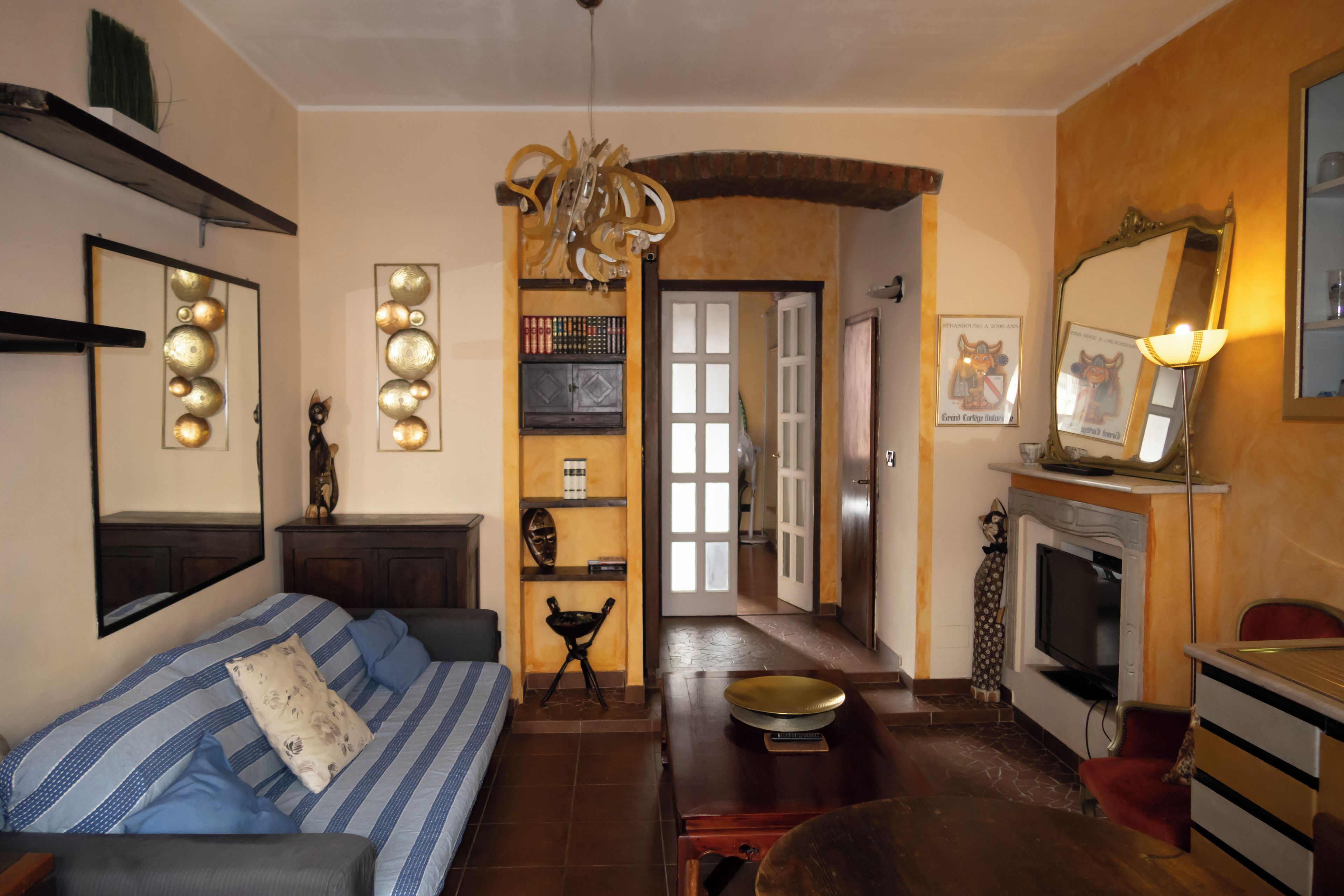 Una sala de estar con sofá, chimenea y comedor con mesa y sillas.