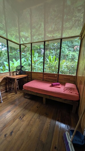 A room with a bed, a desk, and a fan. - Jungle View 2-bedroom lodge with AC in one room. in beautiful Uvita. Bikes Pool (Uvita)
