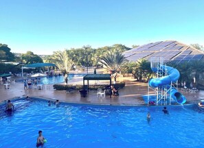 A swimming pool with a water slide and solar panels in the background. - New Listing (Caldas Novas)