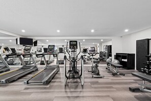 Un gimnasio moderno con máquinas de cardio, pesas y equipo de ejercicio.