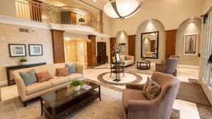 A spacious living area with a high ceiling, a central coffee table, sofas, and a fireplace. - Furnished Downtown SLC 2BR/2BA, 2 Garage Spaces, Desk, 30+ Nights (Salt Lake City)