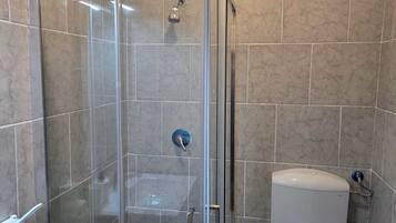 Ein Badezimmer mit Duschkabine, Toilette und Waschbecken.