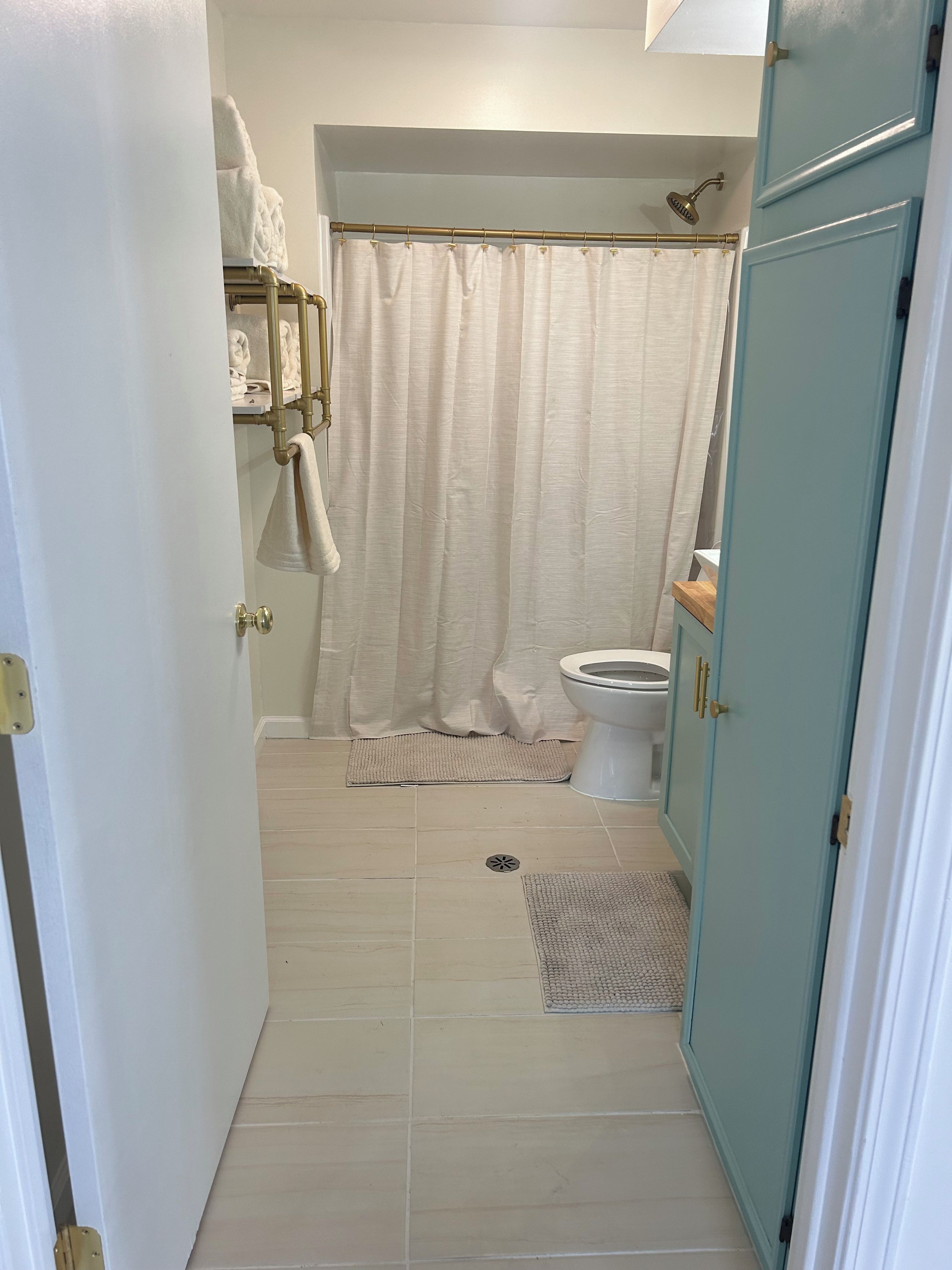 Une salle de bain équipée de toilettes, d’un rideau de douche et d’un porte-serviettes avec des serviettes.