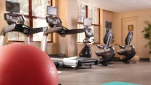 Un gimnasio con cintas de correr y pelotas de ejercicio.