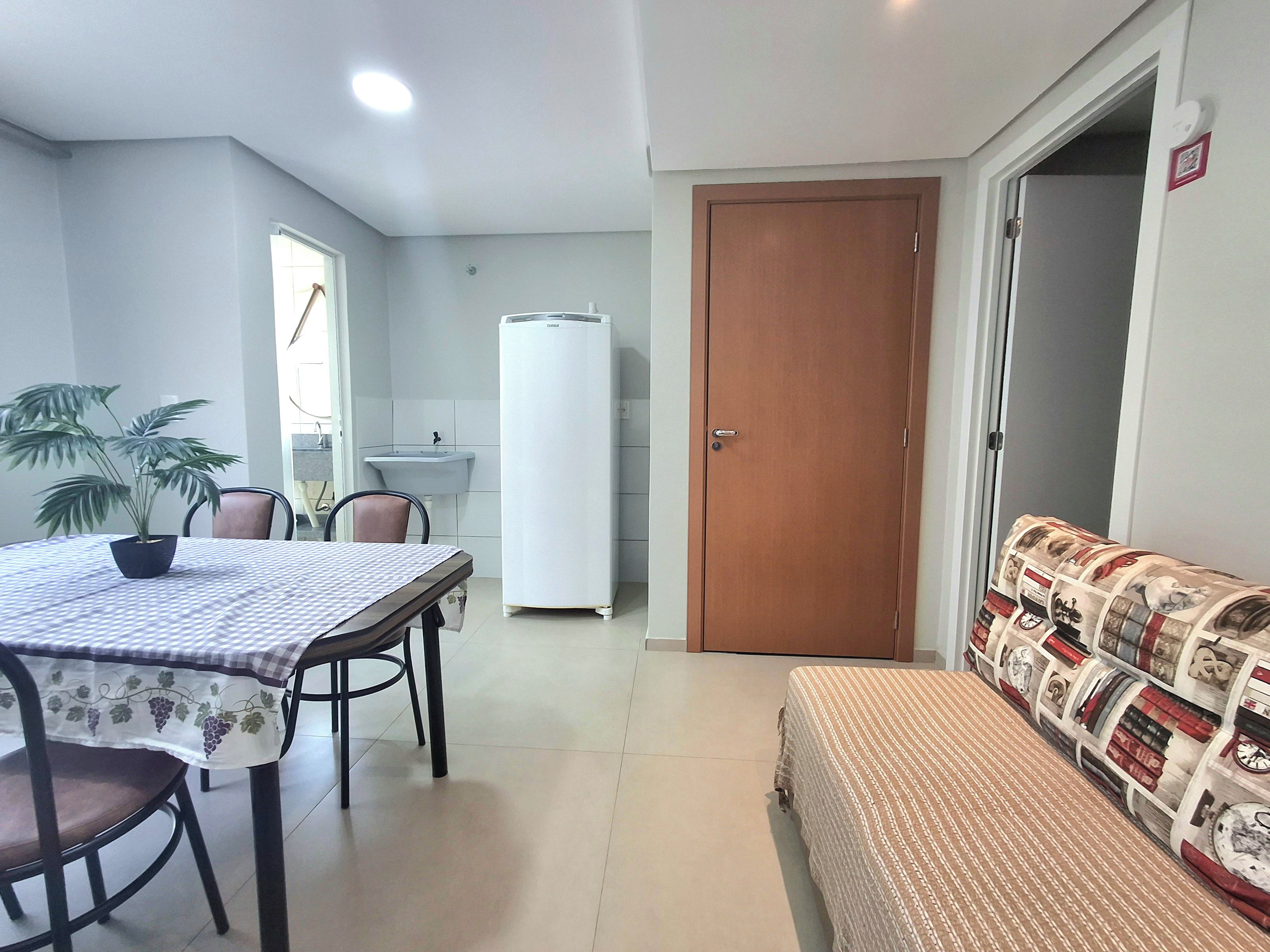 Un espacio habitable compacto con comedor, kitchenette y sofá.