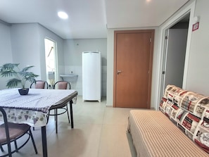 Un espacio habitable compacto con comedor, kitchenette y sofá.