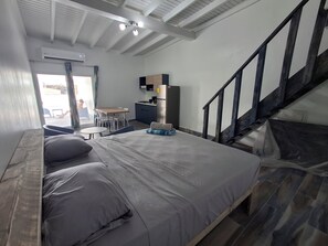 Une chambre à coucher avec un lit, un bureau et un escalier.