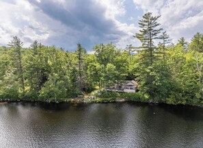 A lakeside cabin with a dock, surrounded by dense forest. - Soothing 2-bedroom cabin in charming Stoneham; perfect for a getaway (Stoneham)