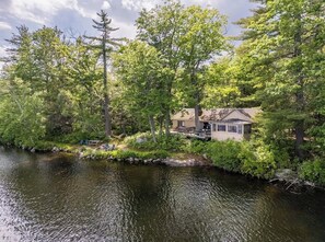 A lakeside cabin with a dock, surrounded by dense forest. - Soothing 2-bedroom cabin in charming Stoneham; perfect for a getaway (Stoneham)