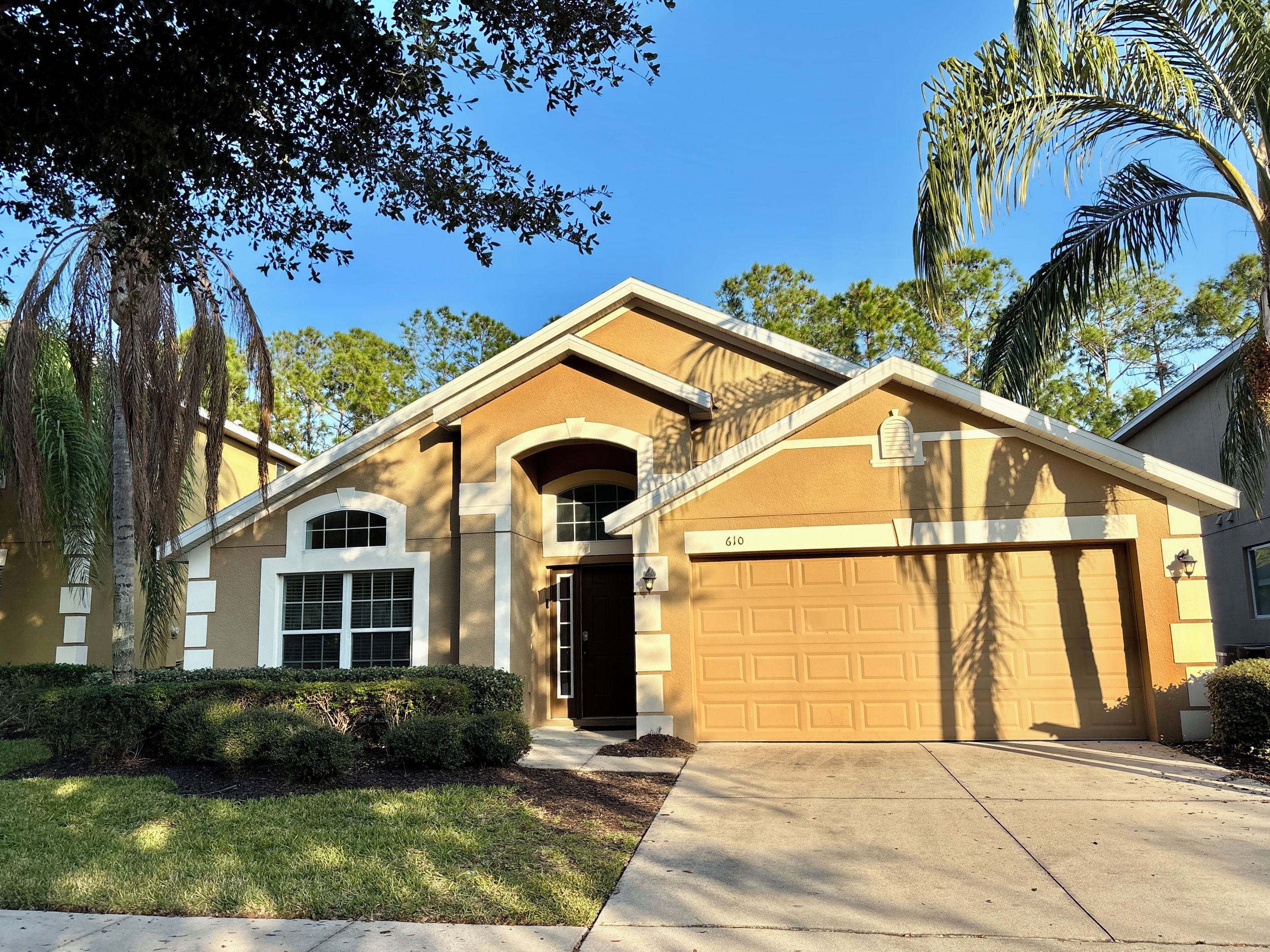 A residential house with a garage, a driveway, and a well-maintained lawn.