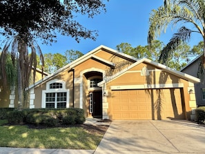 A residential house with a garage, a driveway, and a well-maintained lawn.