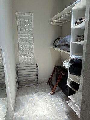 Une pièce de rangement équipée d’étagères, d’un étendoir et d’un meuble de rangement fixé au mur.