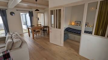 A modern interior with a dining area, a sofa, and a bed.