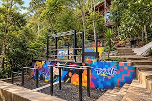 An outdoor gym with colorful graffiti and a wooden structure.