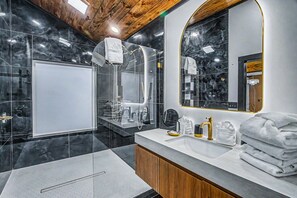 Une salle de bain moderne avec un grand miroir, un meuble-lavabo et un espace douche.