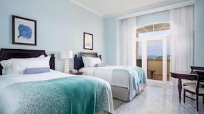 Une chambre d’hôtel avec deux lits, un balcon et une table à manger.