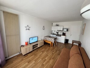 Um espaço compacto com cozinha compacta, área de refeições e zona de estar.