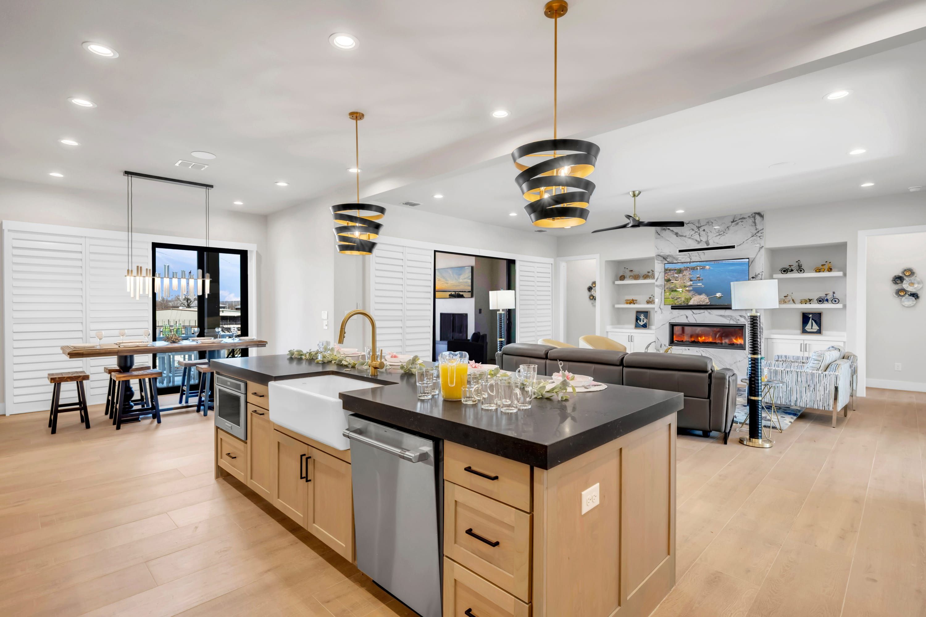 Une cuisine moderne dotée d’un îlot central, de meubles en bois et de luminaires suspendus.