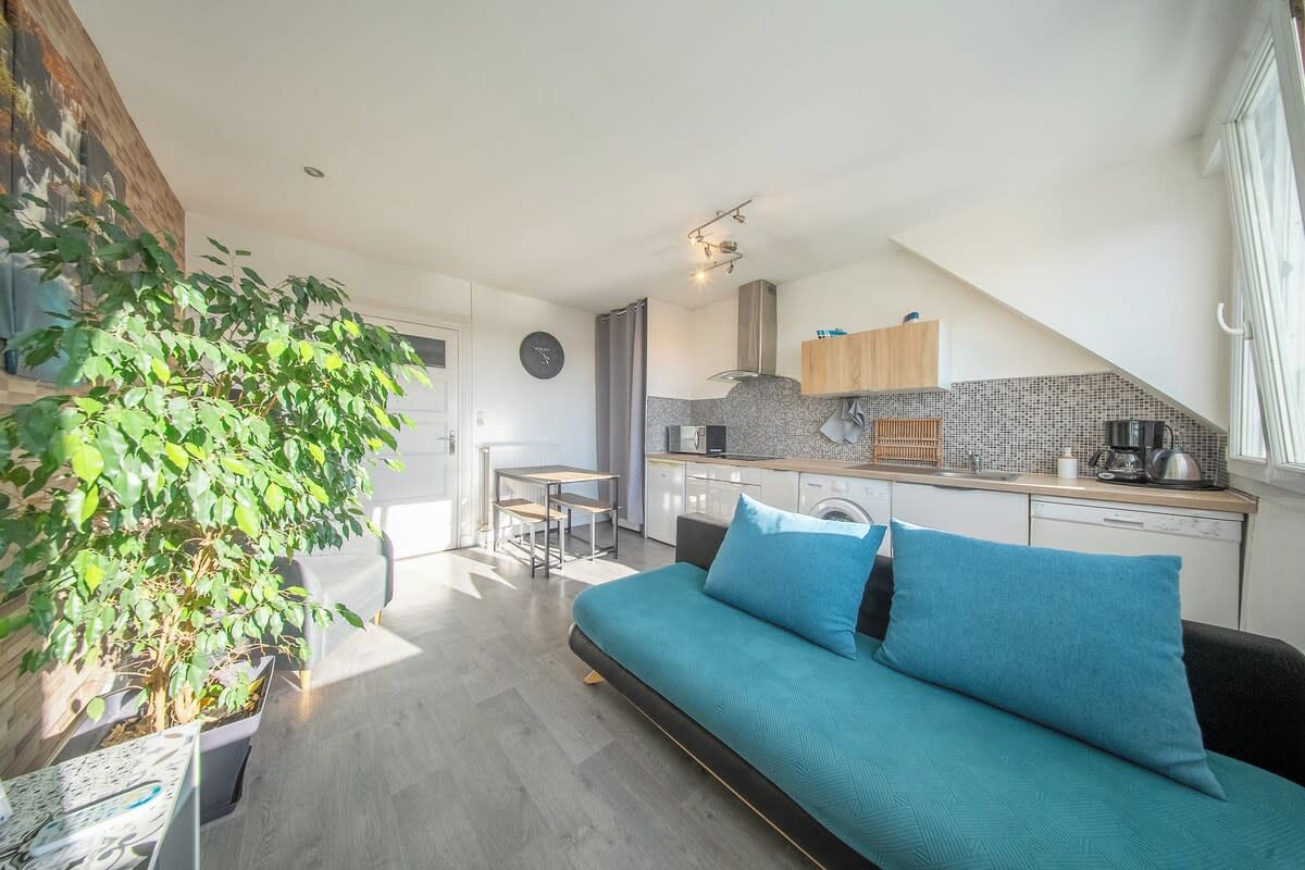 A modern apartment with a kitchenette, a dining area, and a living room with a sofa.