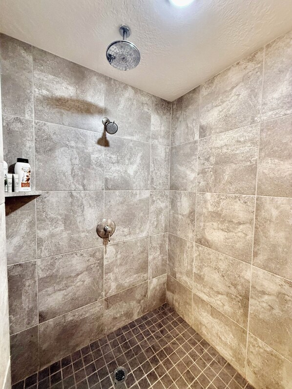 A shower with a handheld showerhead and a wall-mounted faucet. - Penthouse Paradise | Views, Pool & Hot Tub (St George)