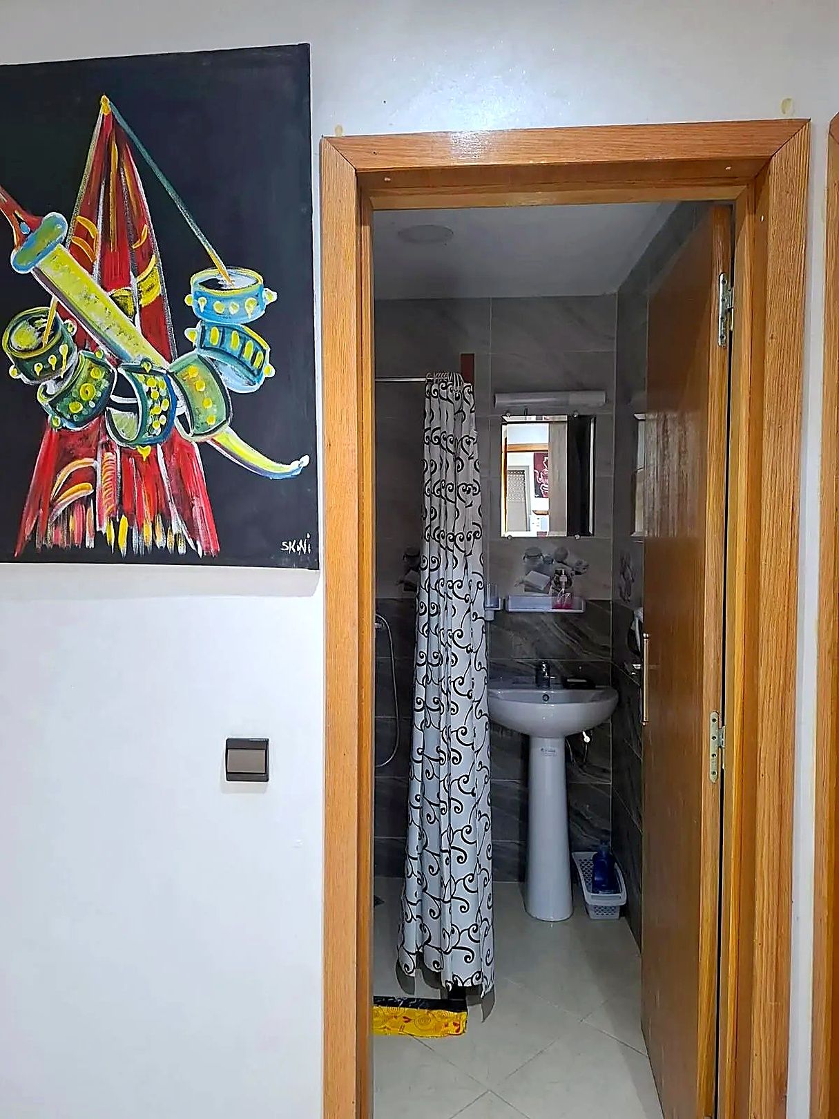 A bathroom with a white sink, a mirror, and a shower curtain.