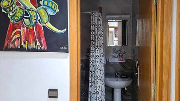 A bathroom with a white sink, a mirror, and a shower curtain.