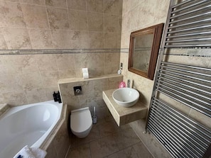 Un baño con bañera, inodoro y lavabo.