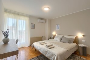 A bedroom with a bed, bedside tables, a desk, and a radiator. - Two bedroom apartment with private swiming pool (Pula)