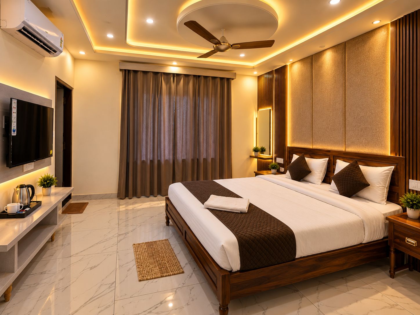 Habitación de hotel moderna con una cama grande, ventilador de techo, aire acondicionado, televisor de pantalla plana y mesita de noche con lámpara.