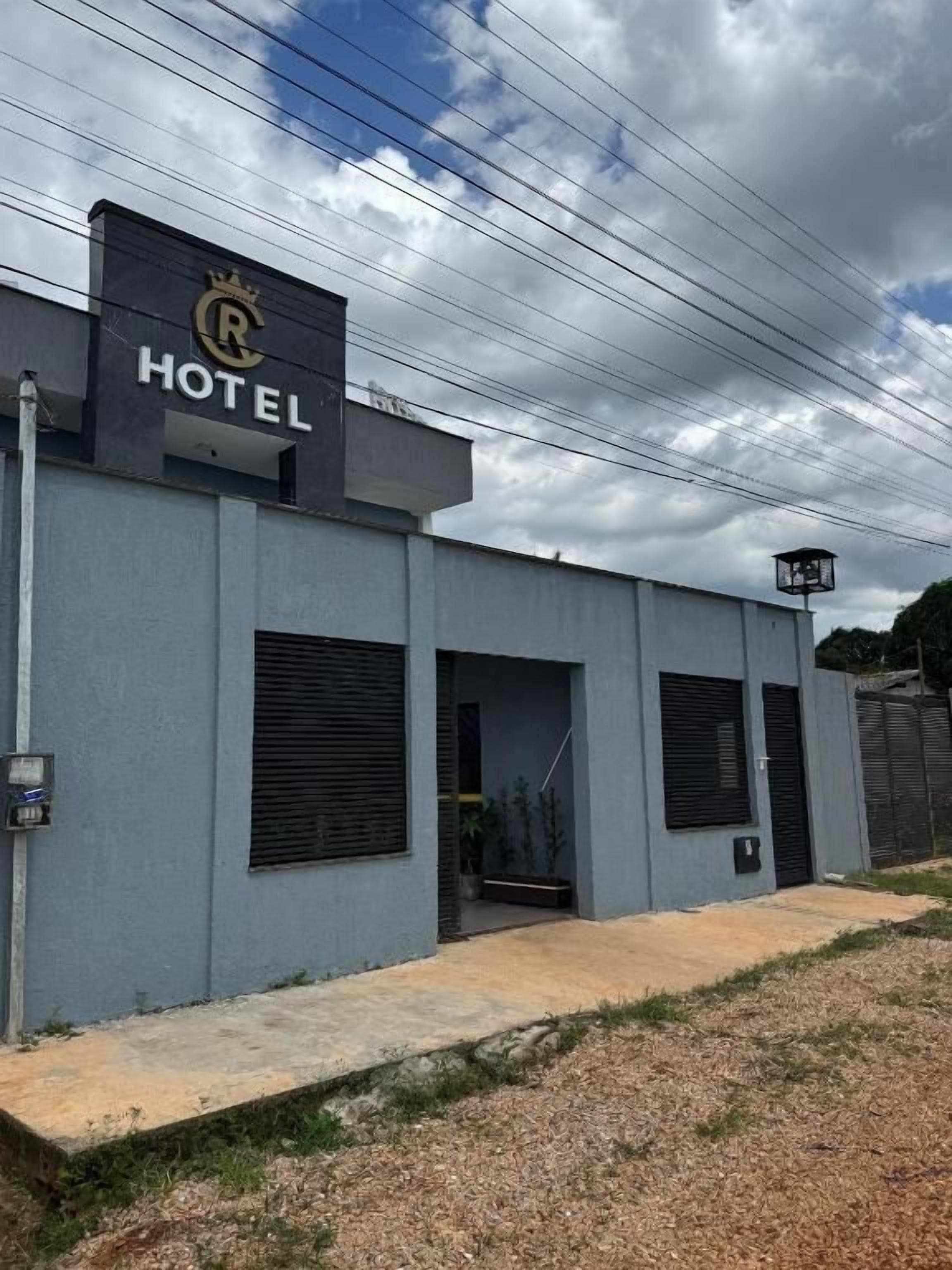 A hotel with a modern facade, a sign with a crown logo, and a covered entrance.