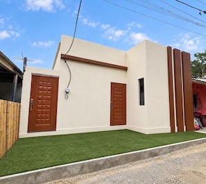Um edifício moderno com duas portas, uma pequena janela e uma tomada na parede.