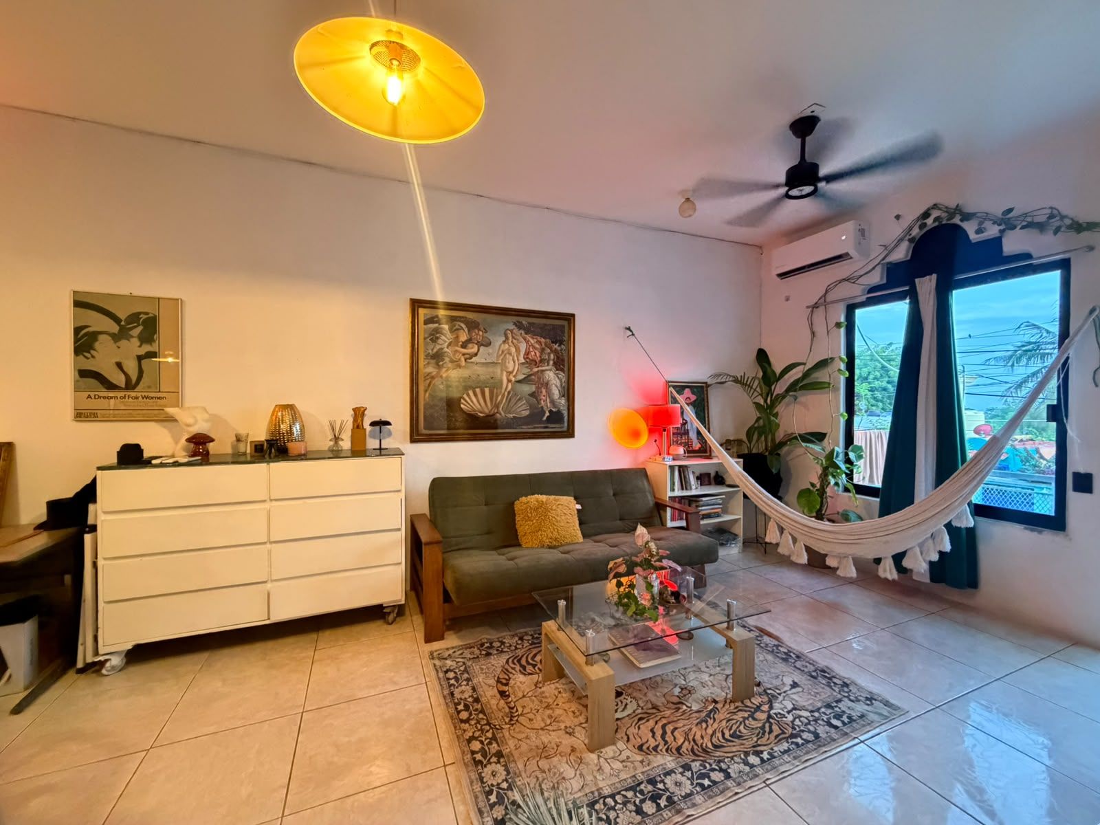A living room with a sofa, coffee table, and a hammock.