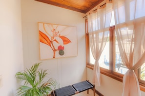 A room with a wooden ceiling, a window with sheer curtains, a plant, and a bench. - Flor de café (Juayúa)