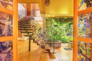 A staircase with ornate metal railings leading to a second floor. - Flor de café (Juayúa)