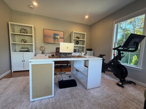 Ein Homeoffice mit Schreibtisch, Computer und Ergometer.