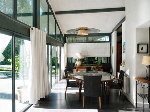 Un espace repas moderne avec une table ronde, des chaises et un luminaire suspendu au plafond.