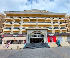 En byggnad med flera våningar, och skylten ”PALMA RESORT” sitter högst upp.