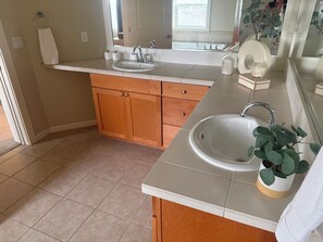 Une salle de bain moderne avec un double lavabo, des meubles en bois et un grand miroir.
