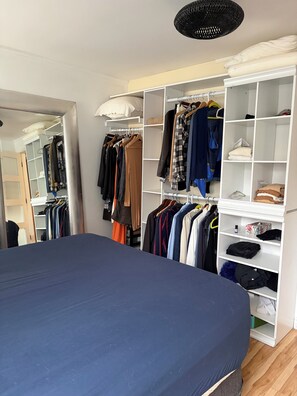 Ein Schlafzimmer mit einem Bett, einem Kleiderschrank und einem Spiegel.